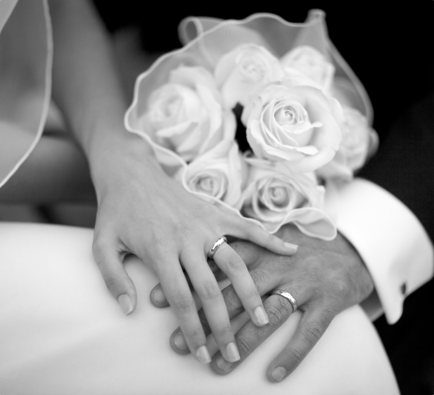 a bride and groom holding hands in grey color
