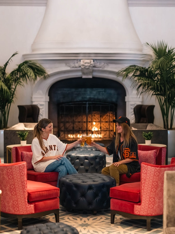 Two women having drinks while dressed up in San francisco sports apparel
