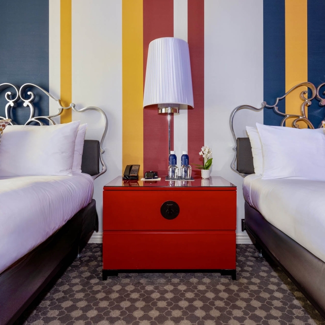 Two beds with a red dresser in the middle at The Marker