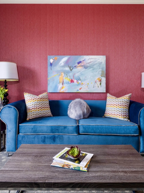 A large blue couch sitting in front of a red wall at The Marker